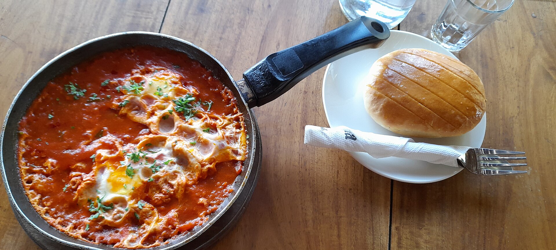Shakshuka (eggs poached in tomato sauce) served with bread for breakfast