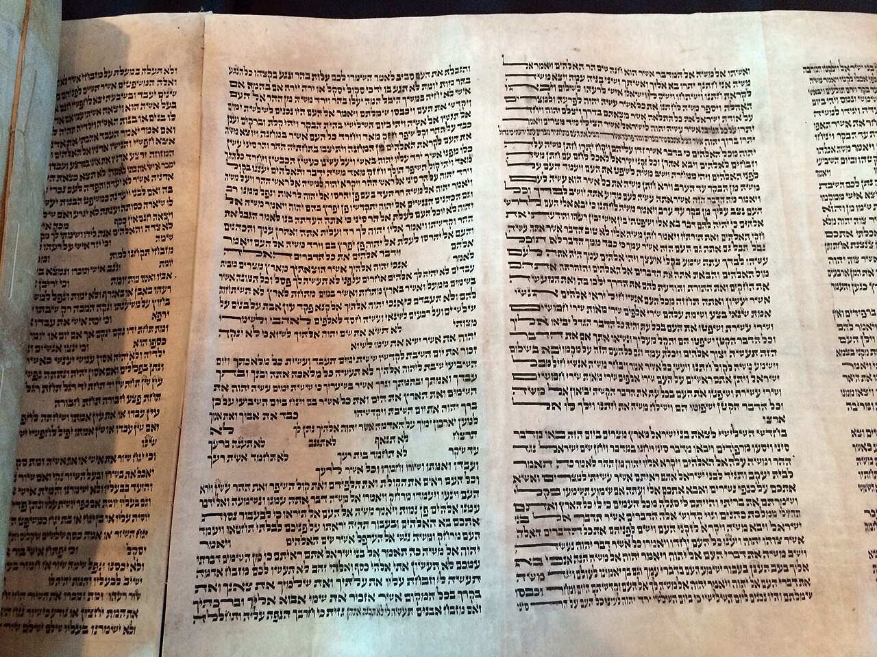 Close-up of a Torah scroll showing the handwritten Hebrew text